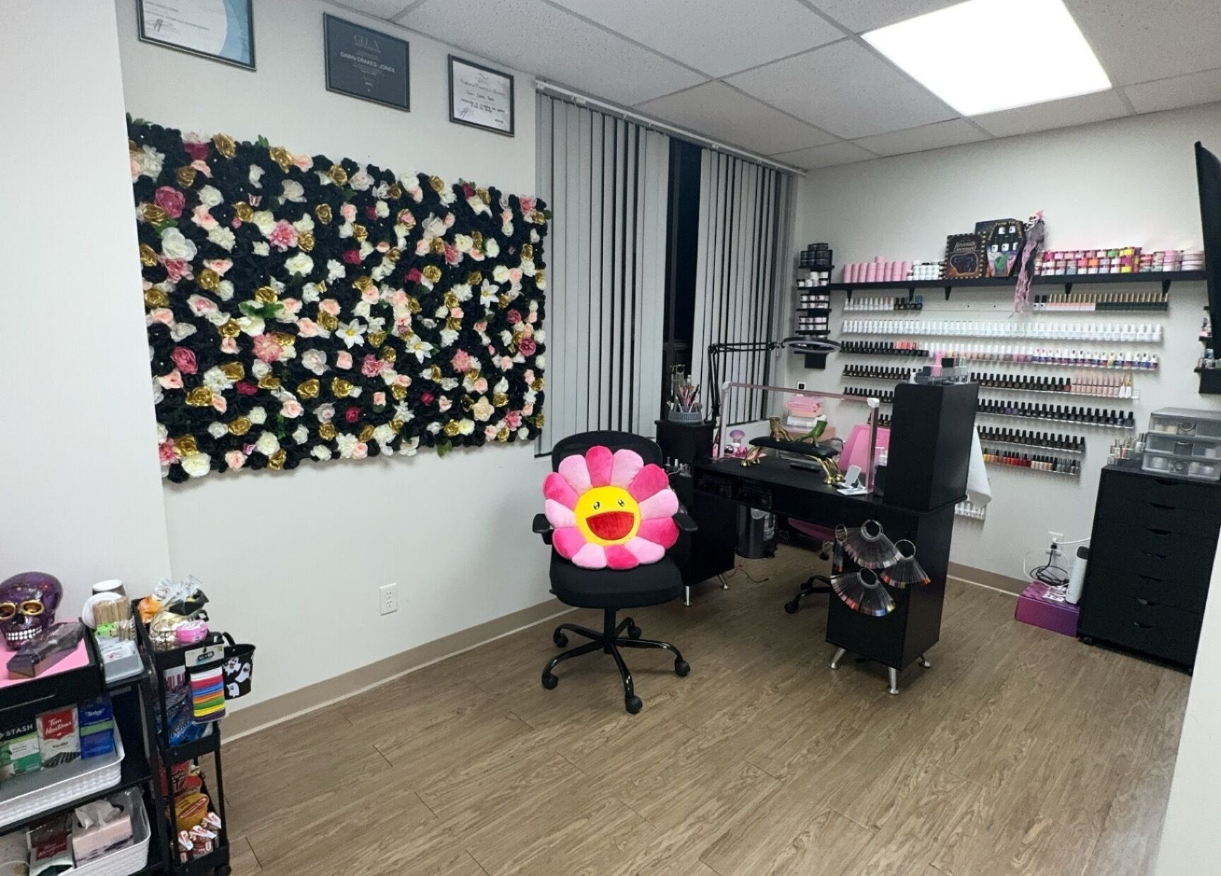 Beauty Girl Studios, Toronto, Ontario, CA. Cozy salon room with floral wall and nail supplies.