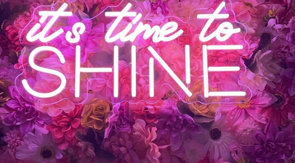 Neon sign 'It's time to shine' with floral backdrop at Beauty Girl Studios, Toronto, Ontario, CA.