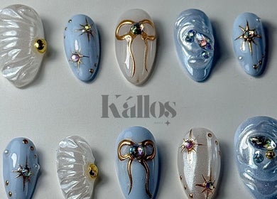 Elegant celestial-themed nail art at Kallos Nails, Racine, Wisconsin, US, featuring stars and metallic accents.