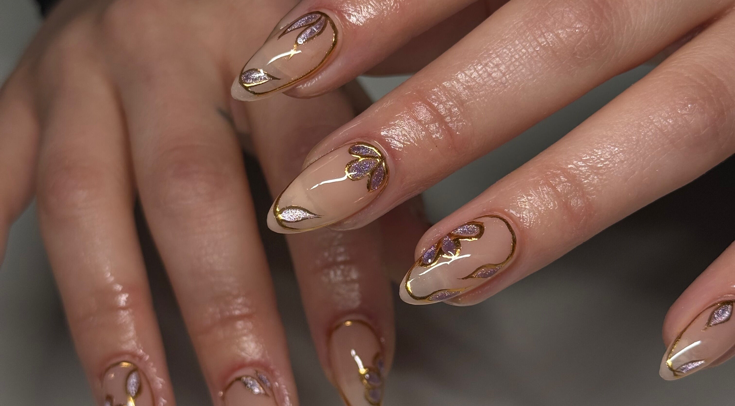 Intricate nail art with gold and purple design at Kállos Nails, Fort Lauderdale, Florida, US.