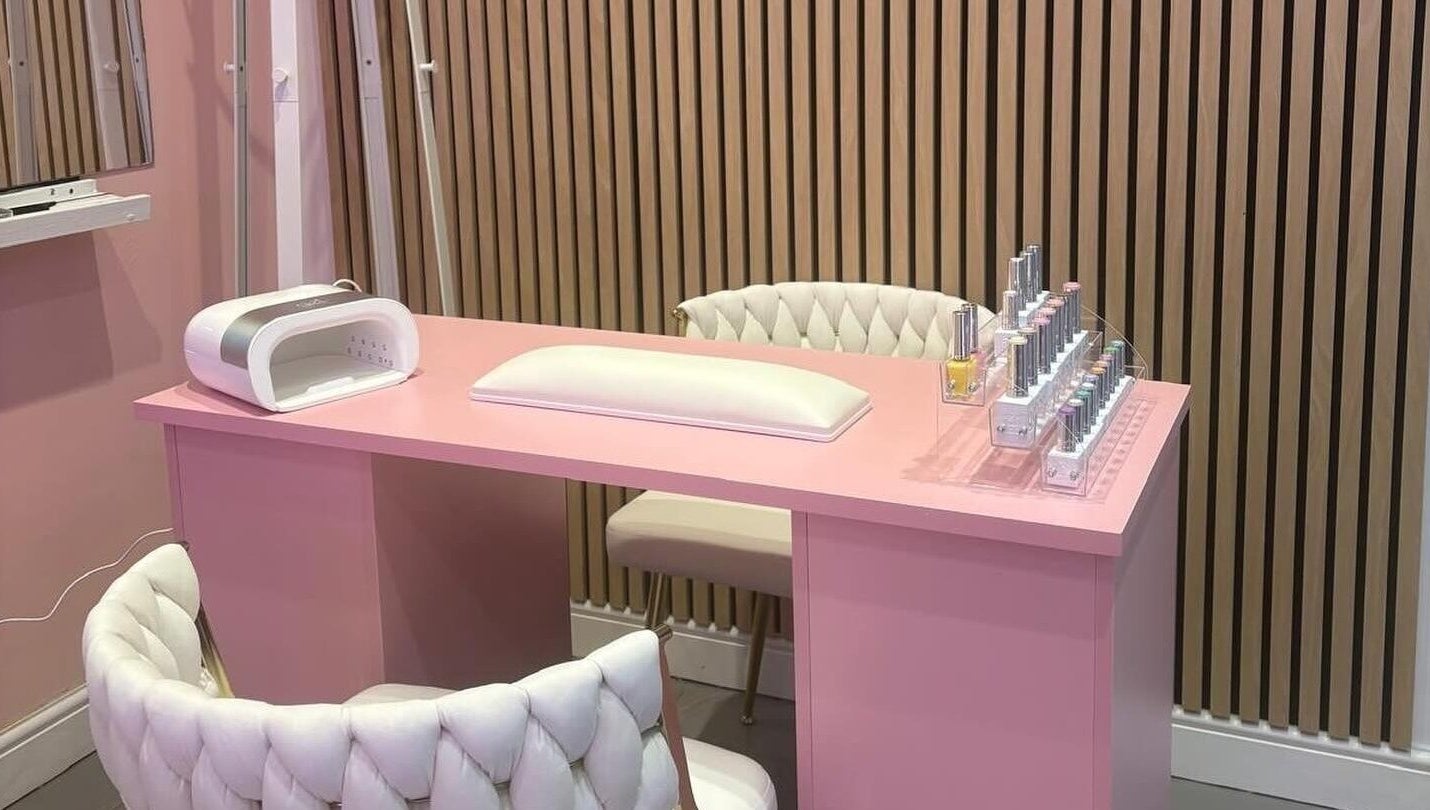 Elegant pink nail station at byzayleigh in Hinckley, England, GB featuring plush chairs and nail polish display.