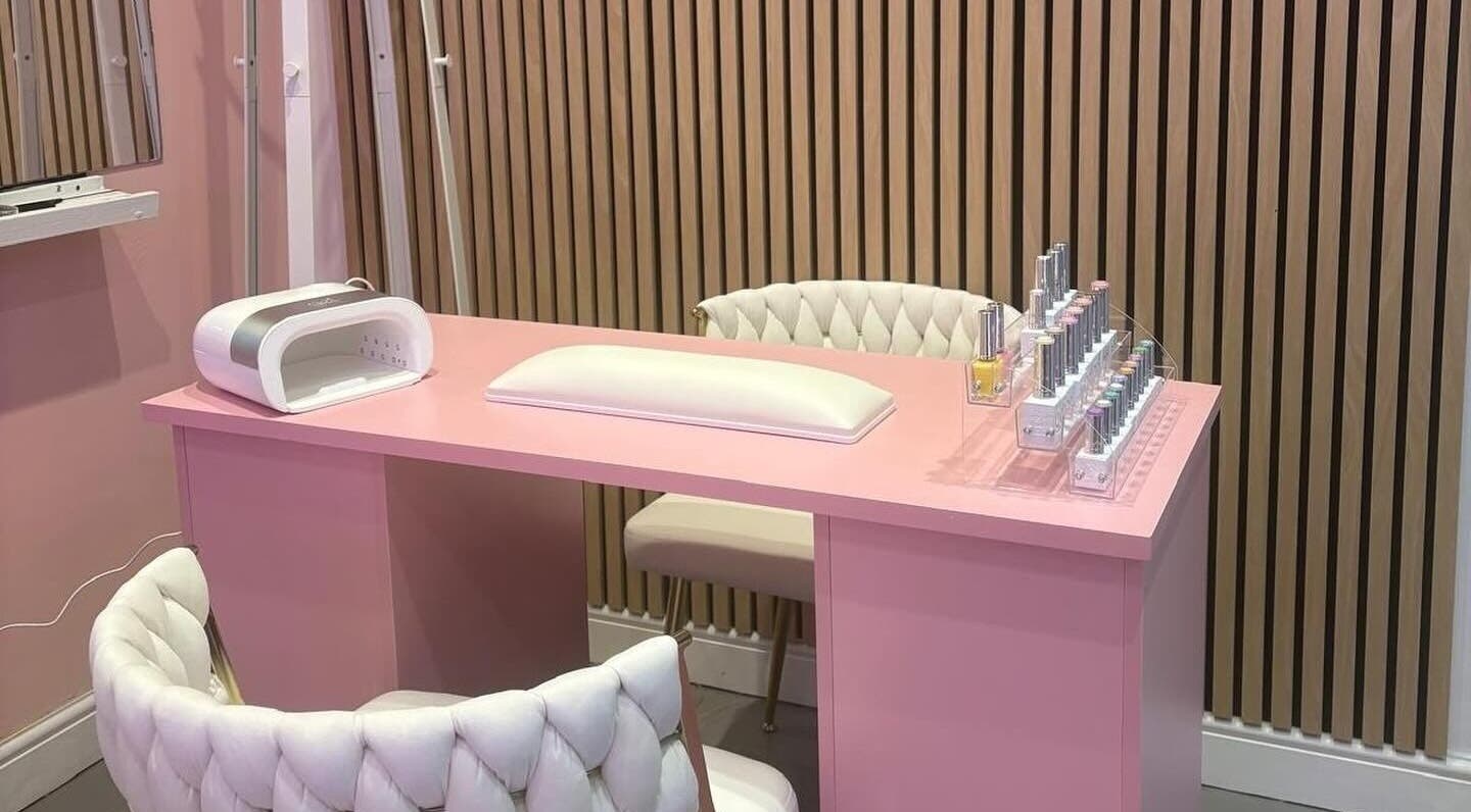 Elegant pink nail station at byzayleigh in Hinckley, England, GB featuring plush chairs and nail polish display.