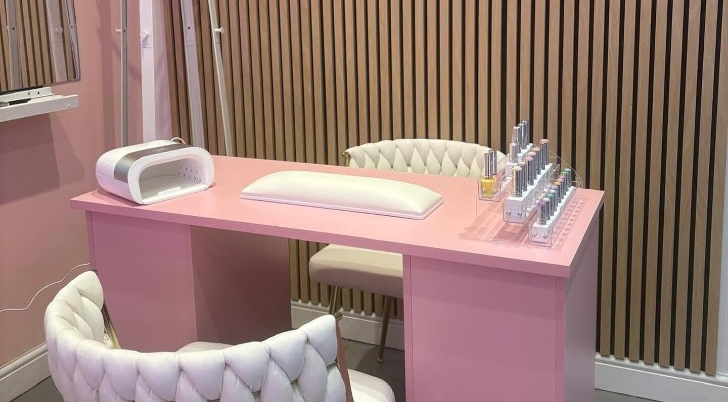 Elegant pink nail station at byzayleigh in Hinckley, England, GB featuring plush chairs and nail polish display.