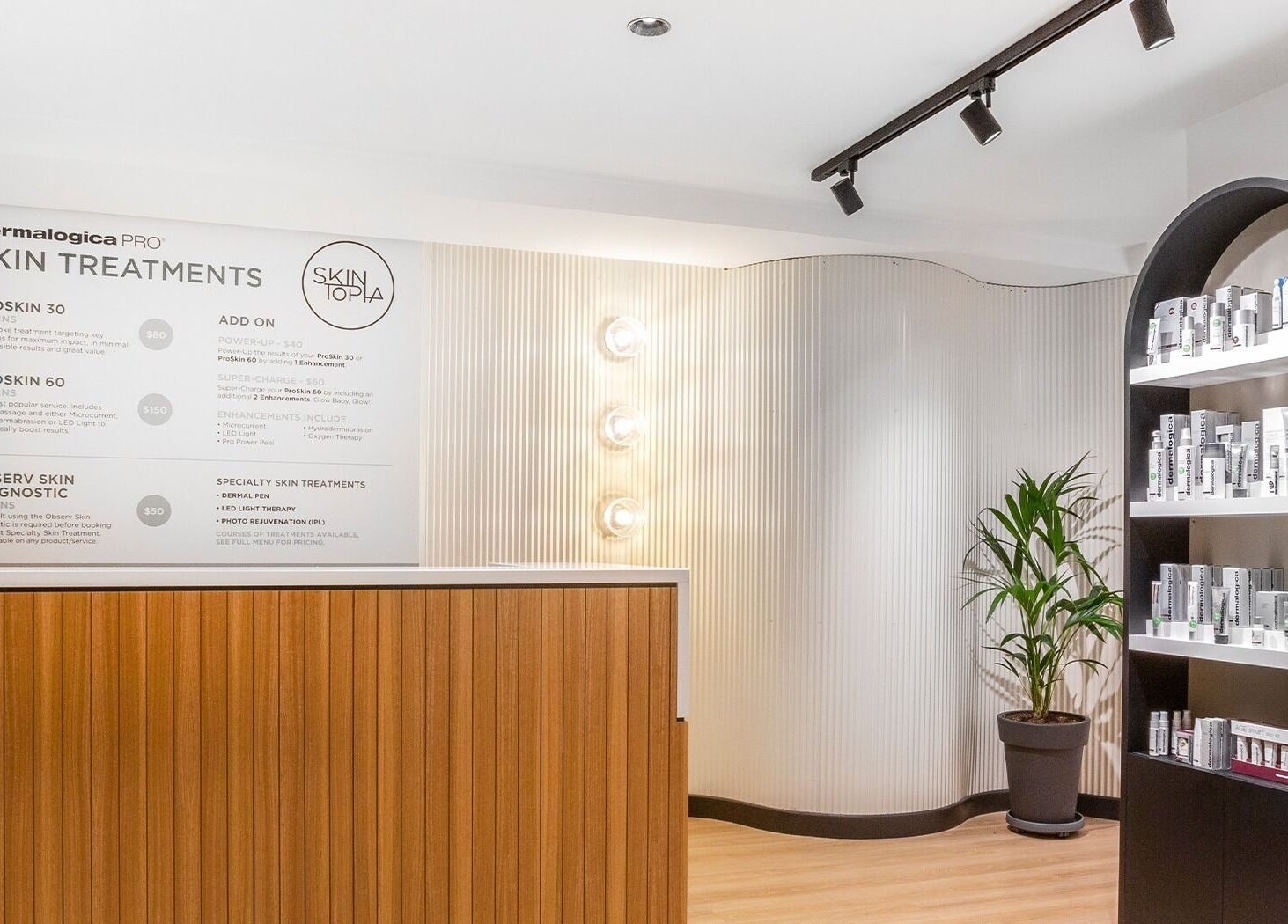 Reception at Skintopia - Old Bank Arcade, Wellington, NZ, featuring skincare products and treatment board.