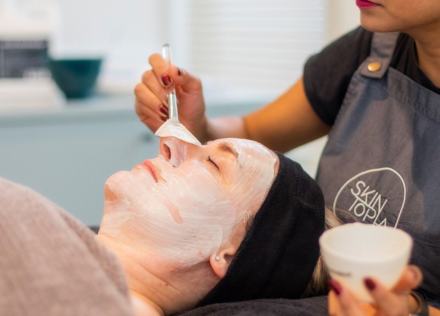 Facial treatment at Skintopia - Khandallah, Wellington, Wellington, NZ. Aesthetician applying mask on client.