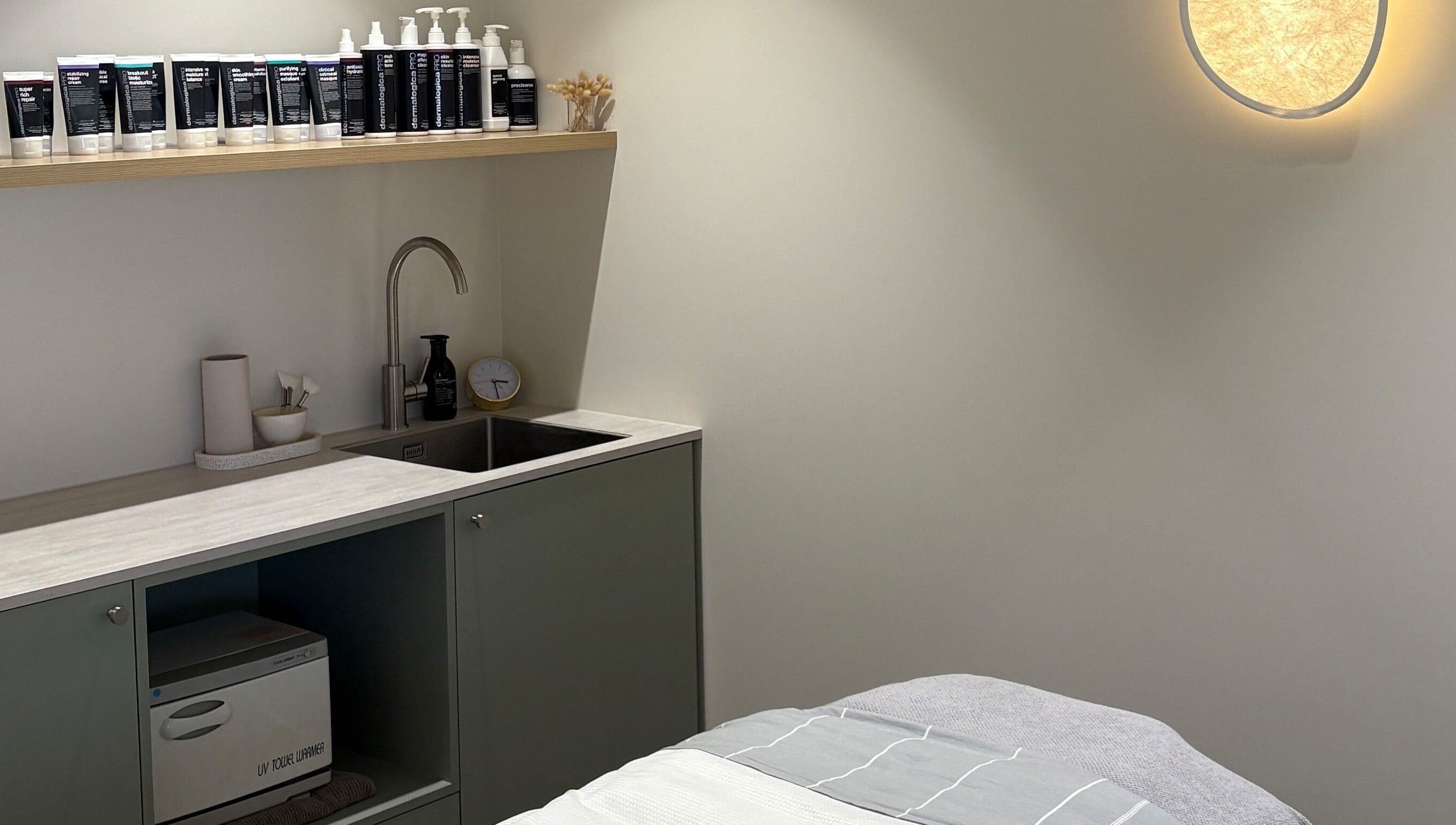 Calm treatment room at Skintopia - Milford, Auckland, NZ, showcasing skincare products and a modern sink area.