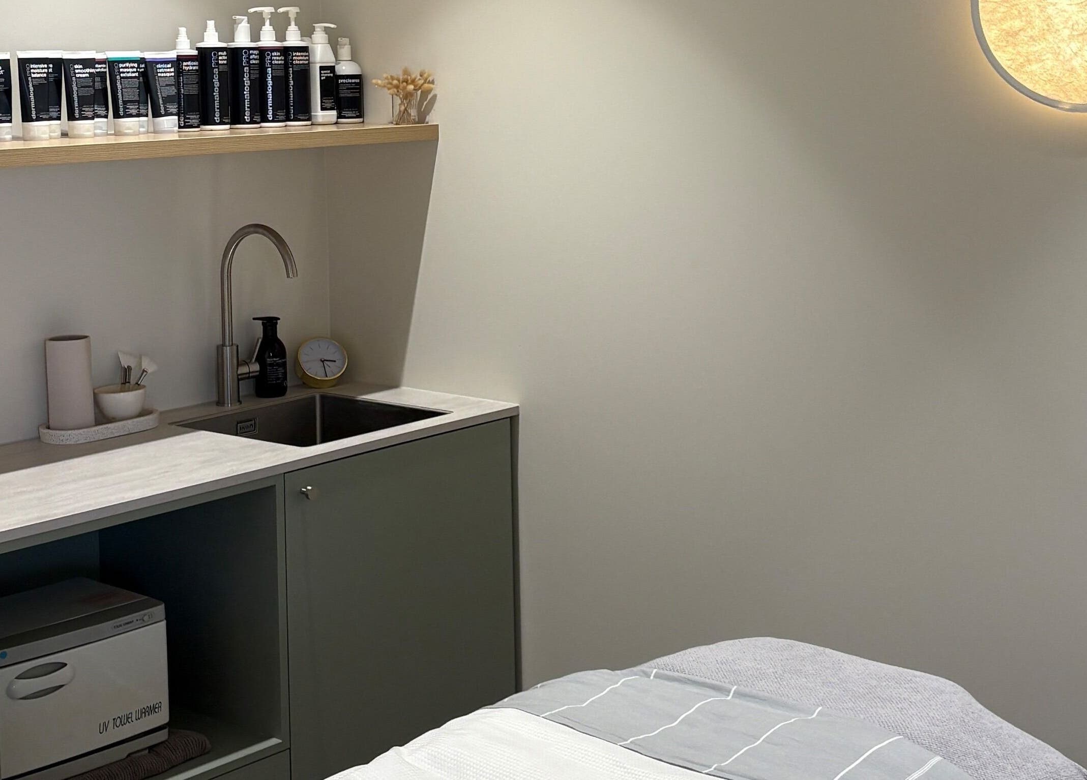 Calm treatment room at Skintopia - Milford, Auckland, NZ, showcasing skincare products and a modern sink area.