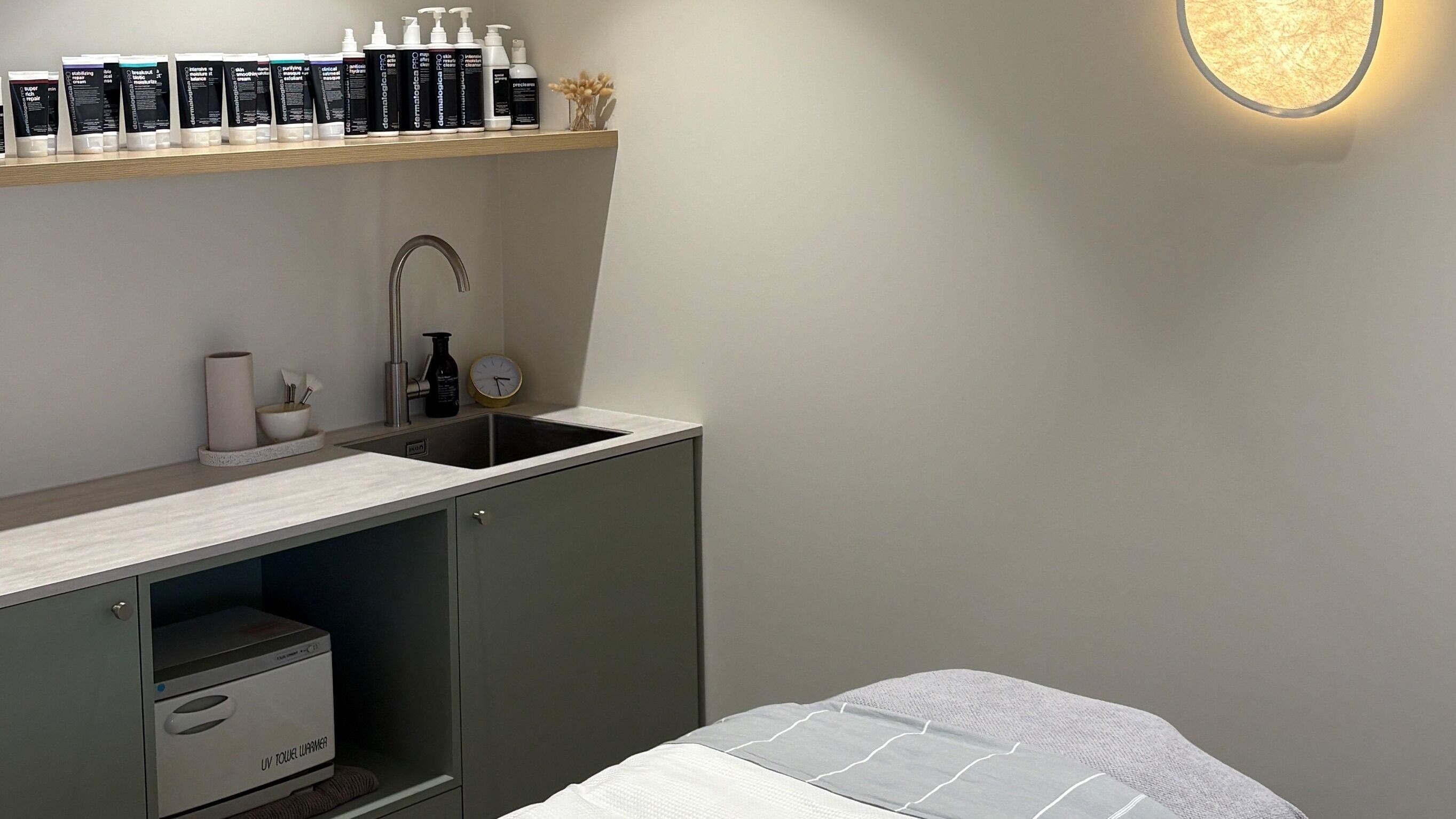 Calm treatment room at Skintopia - Milford, Auckland, NZ, showcasing skincare products and a modern sink area.