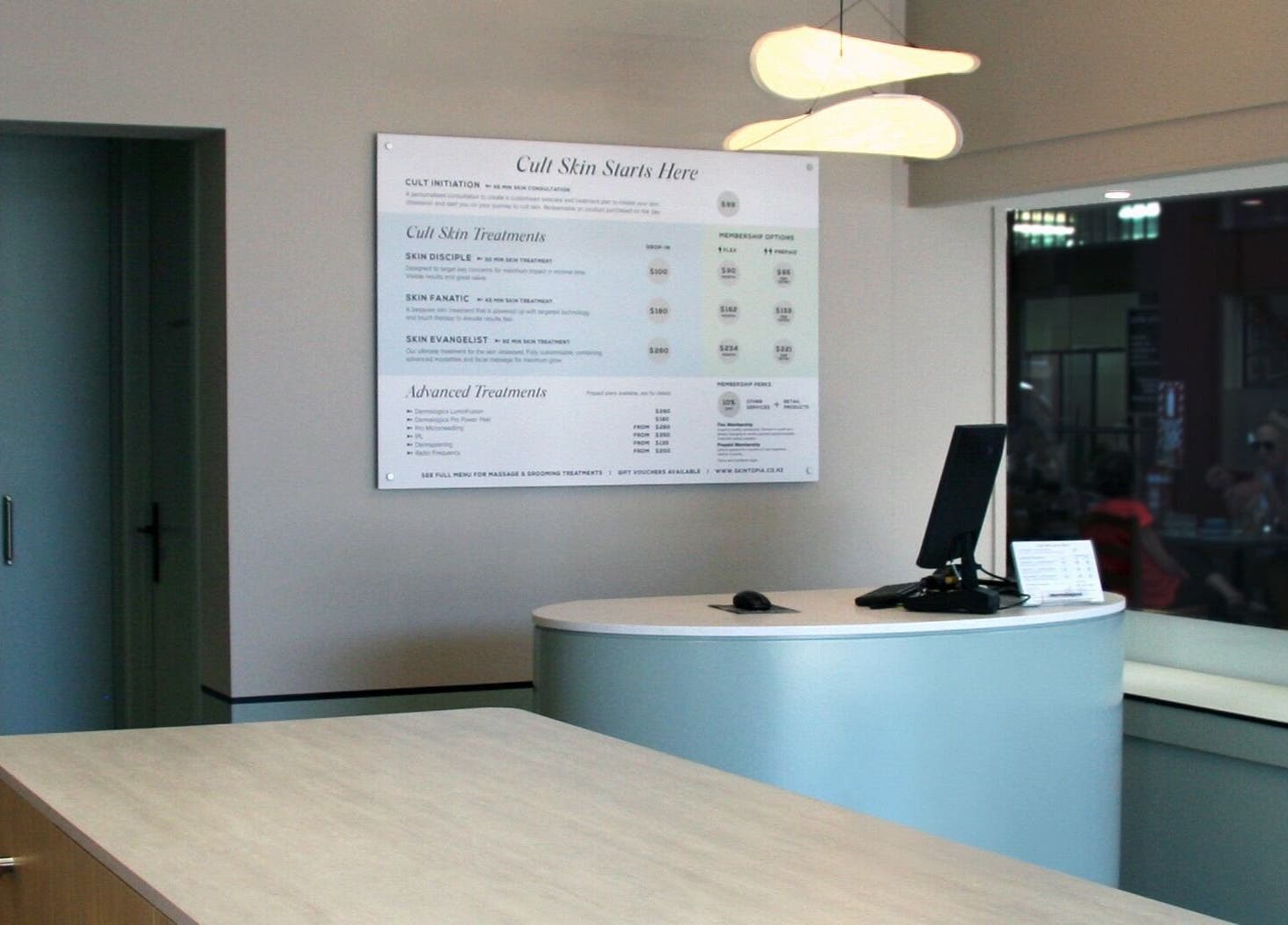 Reception area of Skintopia - Milford in Auckland, NZ highlighting modern desk and soothing ambiance.