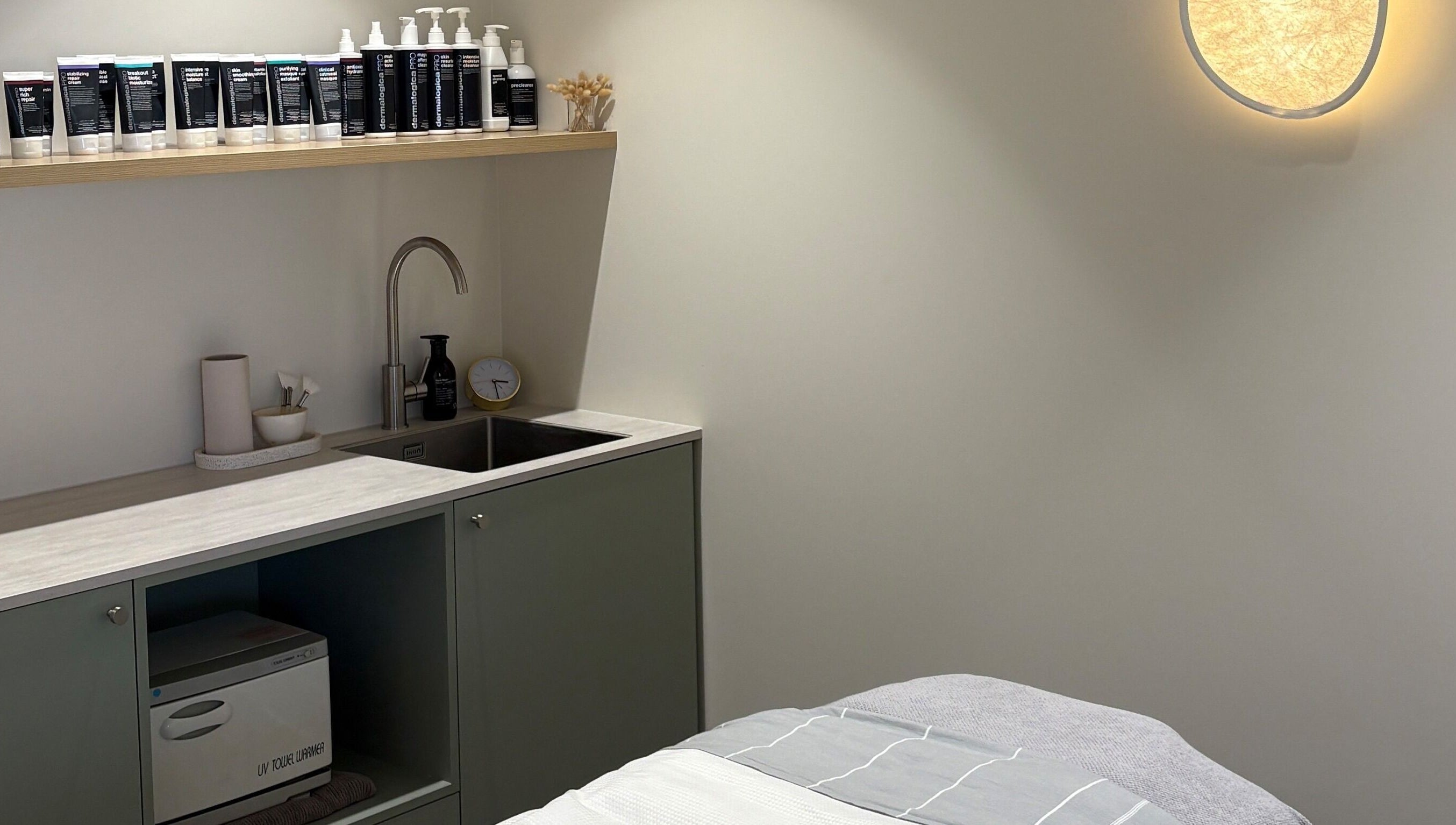 Skintopia - Milford treatment room in Auckland, NZ, featuring a cozy bed and modern amenities.