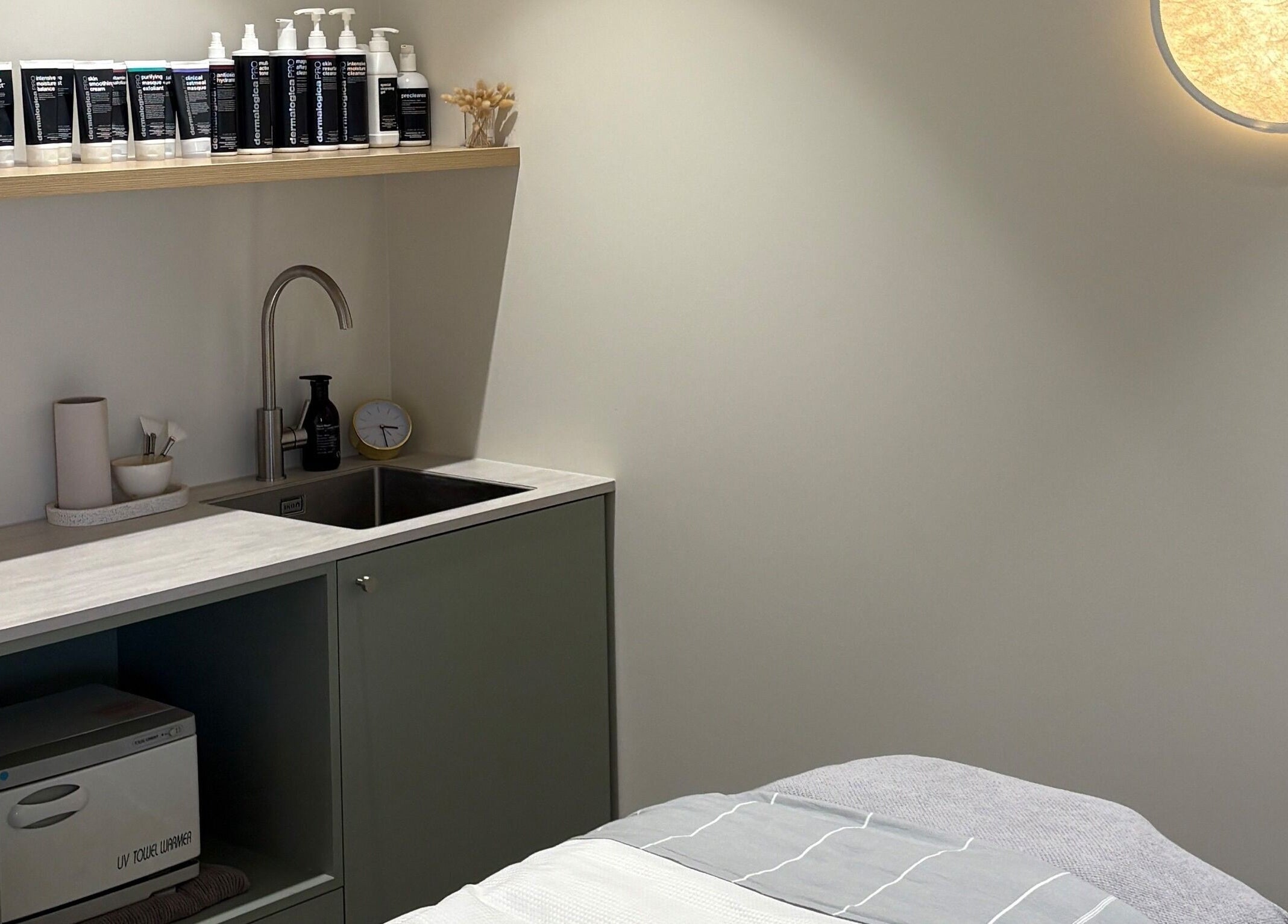 Skintopia - Milford treatment room in Auckland, NZ, featuring a cozy bed and modern amenities.