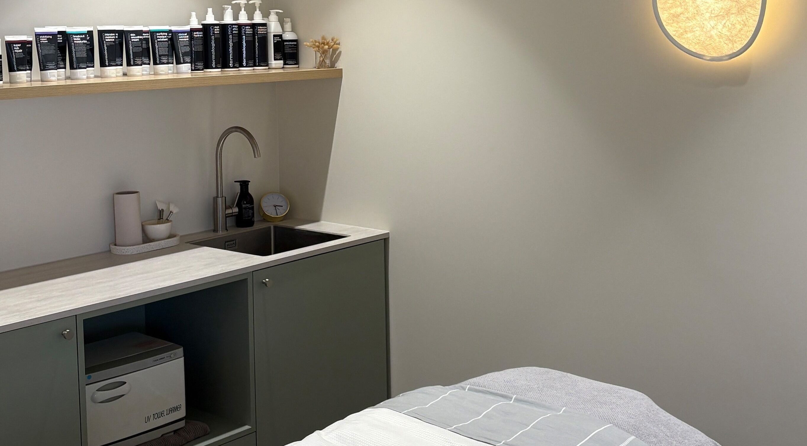 Skintopia - Milford treatment room in Auckland, NZ, featuring a cozy bed and modern amenities.