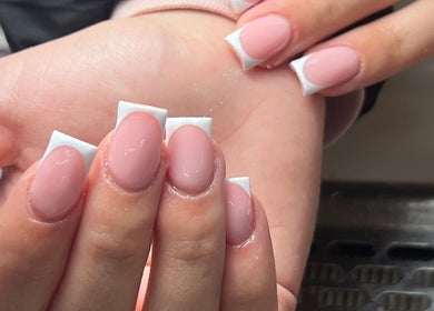 Elegant French manicure at Thebeautyroom, Bulkington, England, GB. Showcasing glossy pink nails with white tips.