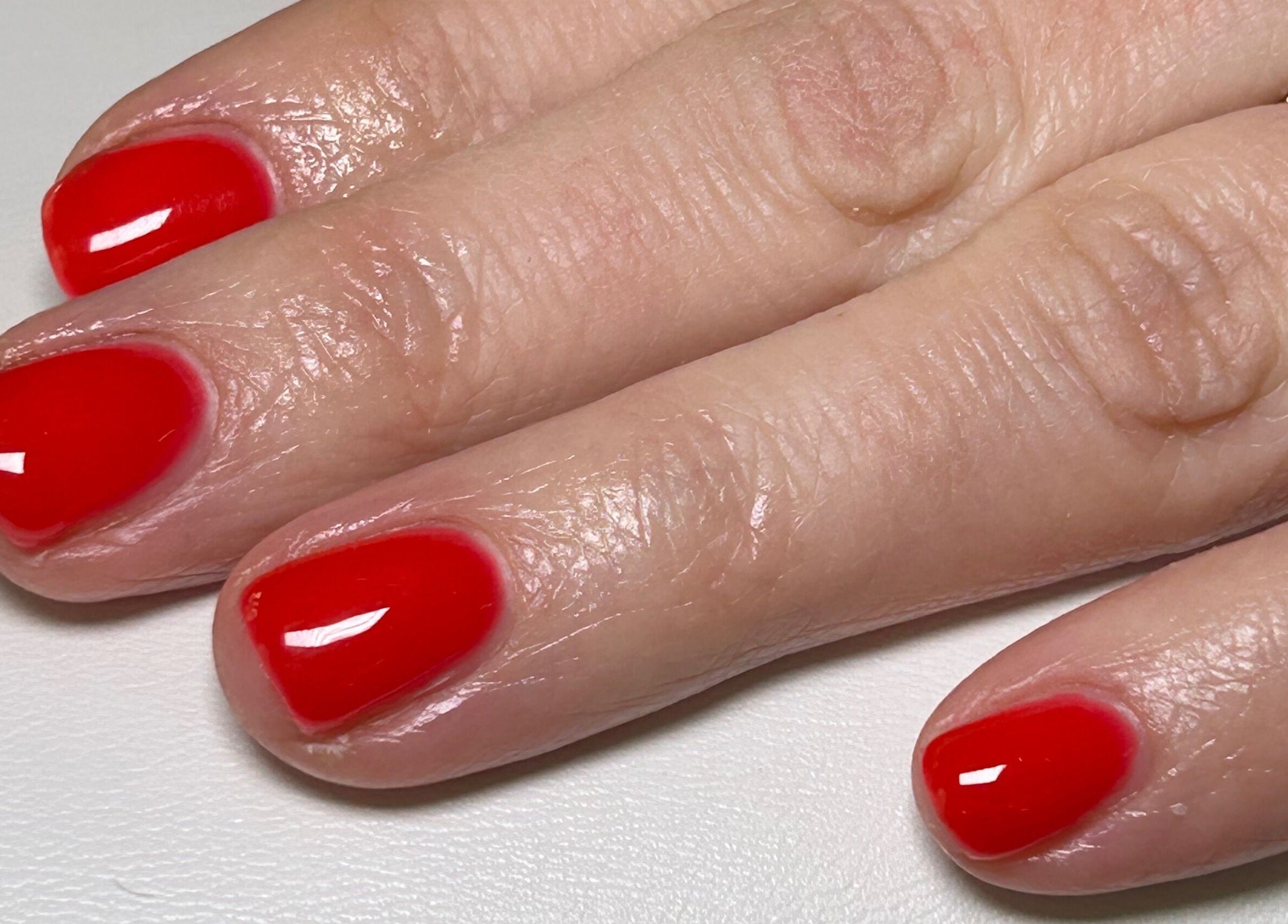 Vibrant red nail polish manicure at The Nail Room at Epsom Downs, Epsom, England, GB.