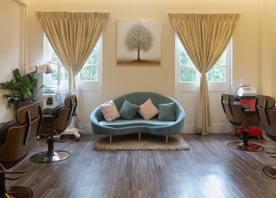 Elegant salon interior at The Hair Lab in Singapore, SG, featuring stylish chairs and a cozy sofa.