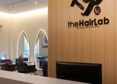Sleek interior at The Hair Lab, Singapore, SG showcasing stylish, modern decor with illuminated mirrors.