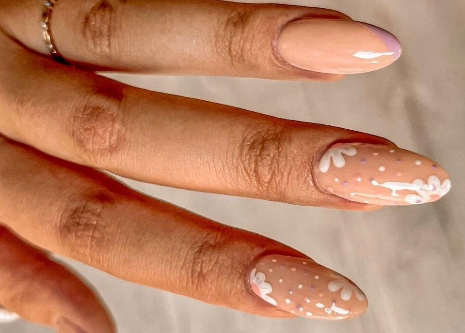 Stylish floral nail art at MF Nail Artist, Rustenburg, North West, ZA shows delicate white designs on nude polish.