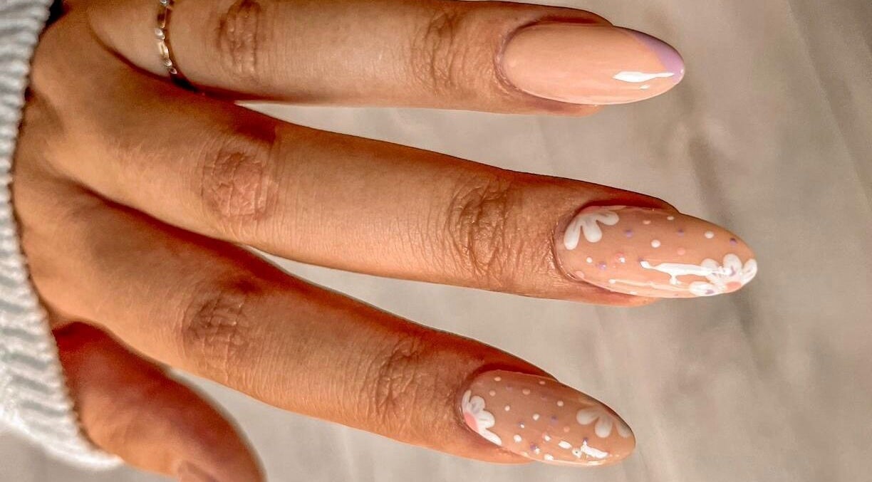 Stylish floral nail art at MF Nail Artist, Rustenburg, North West, ZA shows delicate white designs on nude polish.