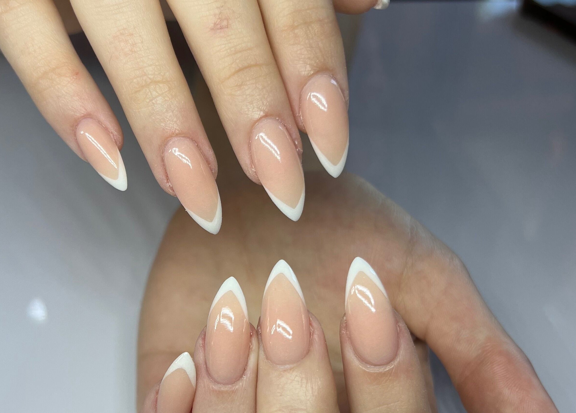 Elegant French manicure at MF Nail Artist, Rustenburg, North West, ZA, showcasing glossy nude nails with white tips.