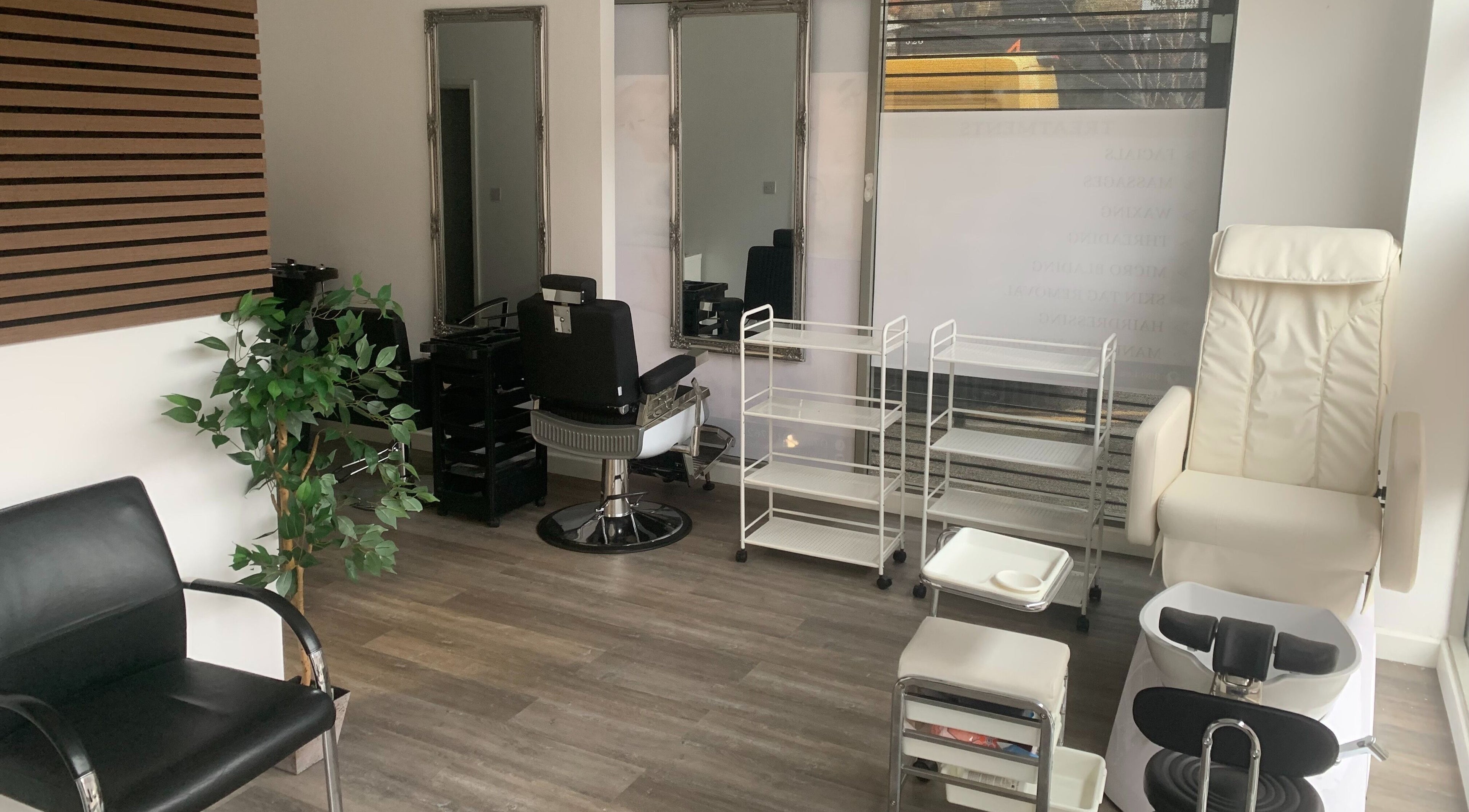 Stylish salon interior at Entice Beauty Lounge in London, England, GB, featuring chairs and mirrors.