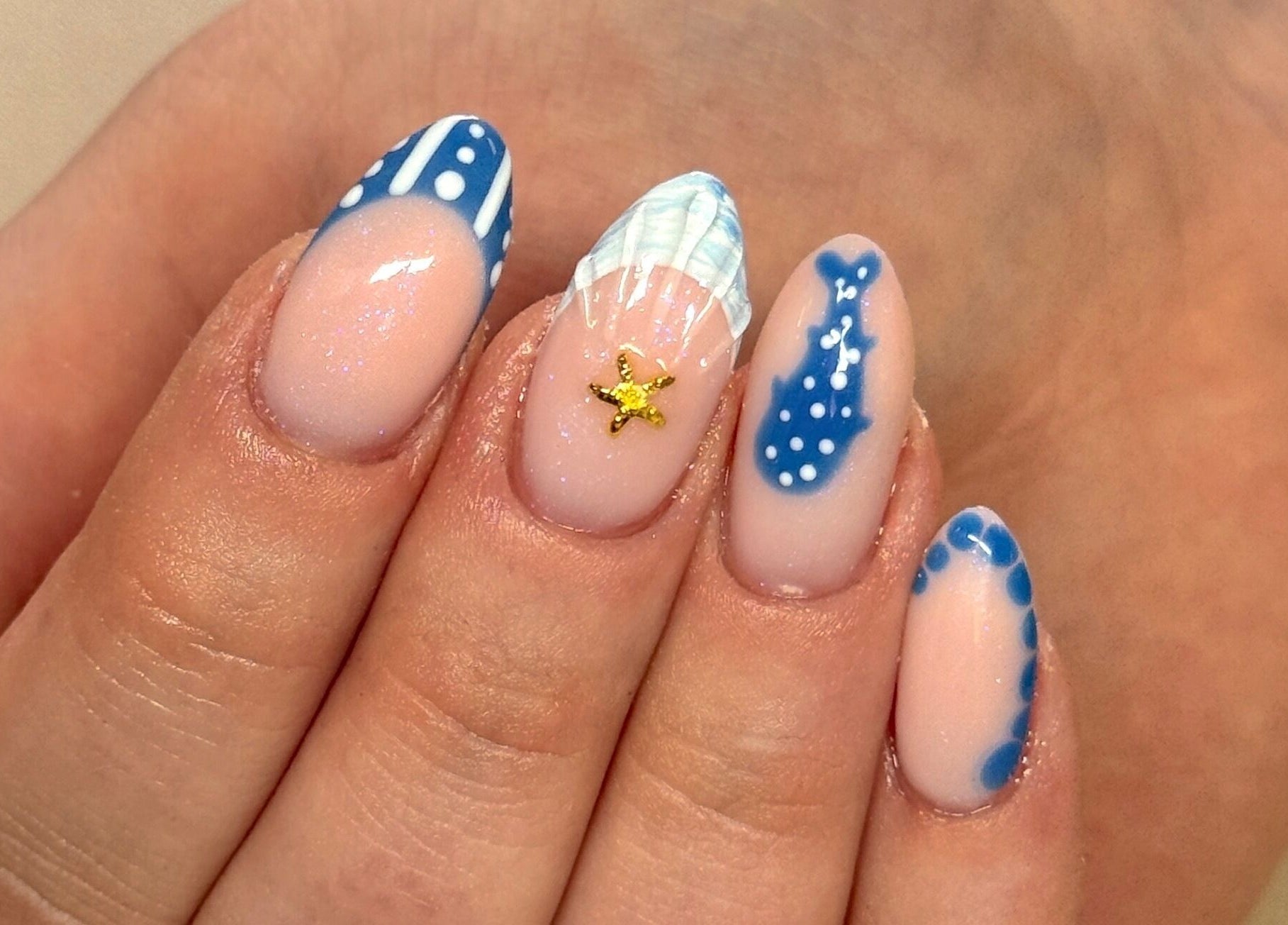 Detailed ocean-themed nail art at Nailsby Georgia, Saint Helens, England, GB. Blue designs and starfish accent.