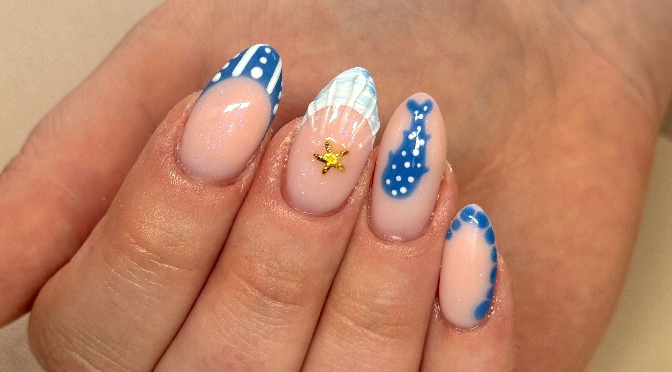 Detailed ocean-themed nail art at Nailsby Georgia, Saint Helens, England, GB. Blue designs and starfish accent.