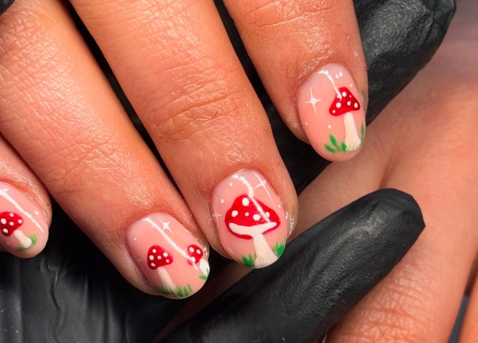 Mushroom nail art at Nailsby Georgia, Saint Helens, England, GB. Intricate red mushroom designs on fingertips.