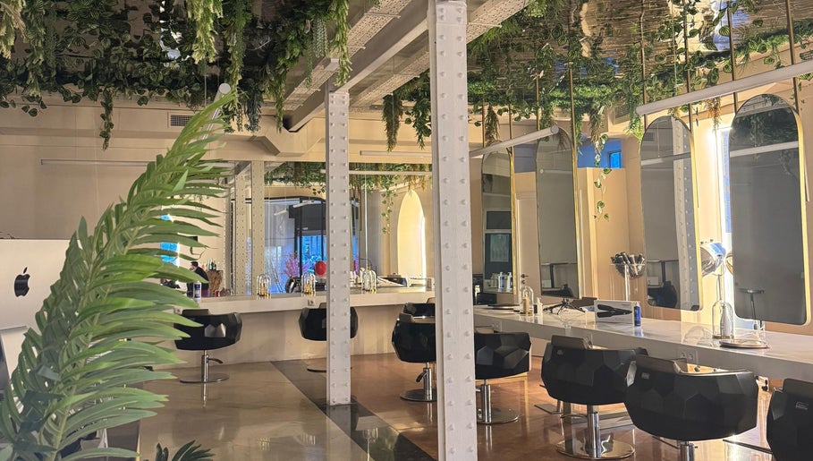 Interior de Lorena Morlote Multiespacio en Madrid, con vegetación colgante y sillas modernas.