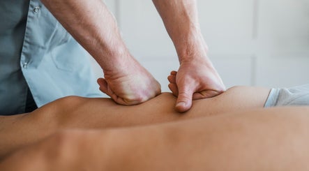 Massage therapy at Jon Foxall Sports Massage, Loughborough, GB shows hands applying pressure on a back.