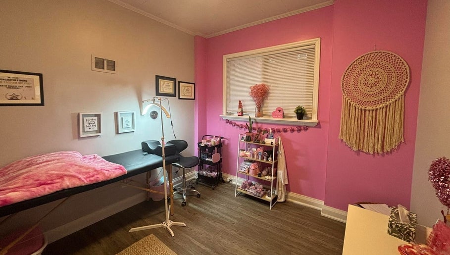 Cozy pink interior of Lash + Headspa Suite, Fort Erie, Ontario, CA. Features treatment bed and decor.