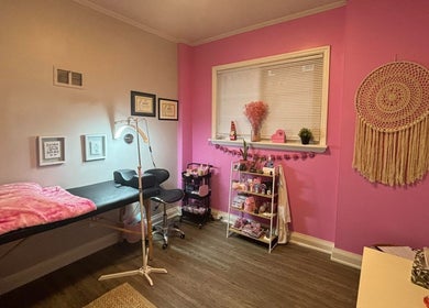 Cozy pink interior of Lash + Headspa Suite, Fort Erie, Ontario, CA. Features treatment bed and decor.
