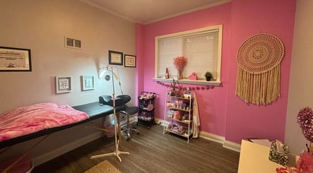 Cozy pink interior of Lash + Headspa Suite, Fort Erie, Ontario, CA. Features treatment bed and decor.