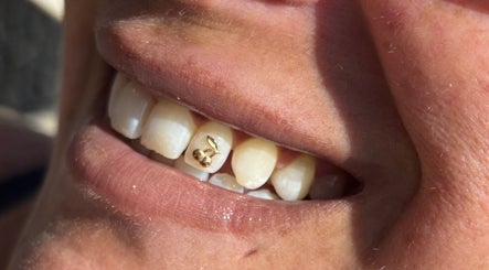 Close-up of gold tooth gem in vibrant smile at Lash + Headspa Suite, Fort Erie, Ontario, CA.