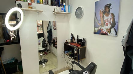 Interior de Barber Studio L.N en Rosario, Santa Fe, AR. Silla de barbero y productos en estantes blancos.