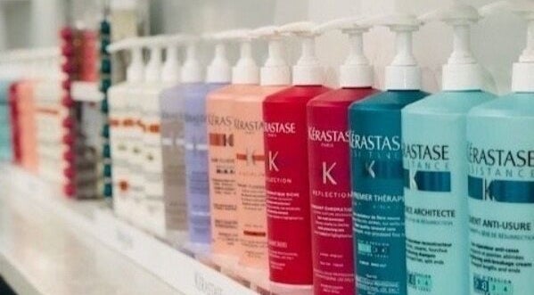 Shelf of colorful haircare bottles at Miva Salon - B Street, Hayward, California, US.