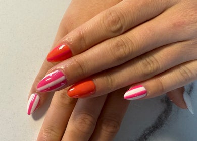 Colorful nail art at Nails By Emm in Duncan, South Carolina, US, showcasing vibrant pink and orange designs.