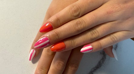 Colorful nail art at Nails By Emm in Duncan, South Carolina, US, showcasing vibrant pink and orange designs.