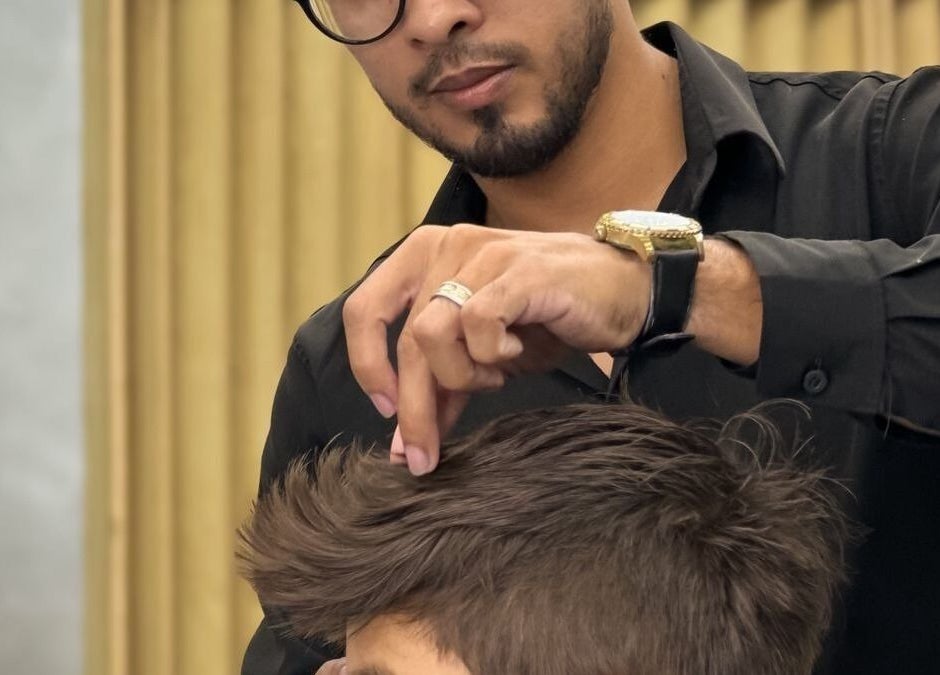 Barbeiro da RL7 BARBEARIA em Ceará, Ceará, BR, aperfeiçoando penteado de cliente.