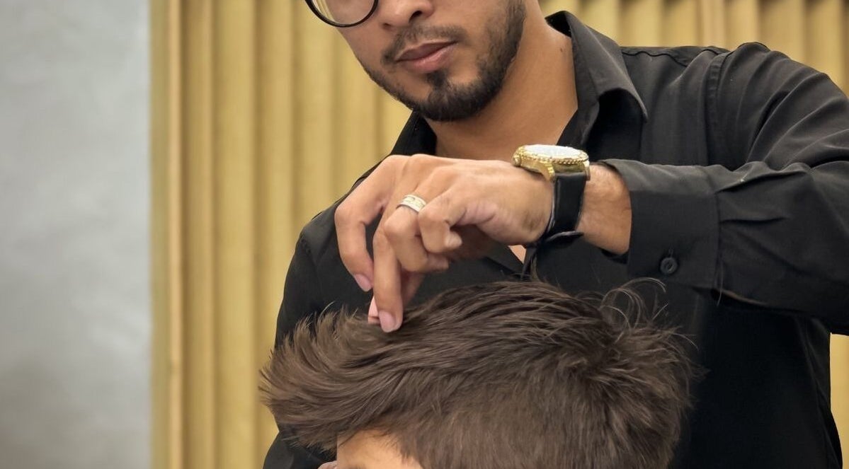 Barbeiro da RL7 BARBEARIA em Ceará, Ceará, BR, aperfeiçoando penteado de cliente.