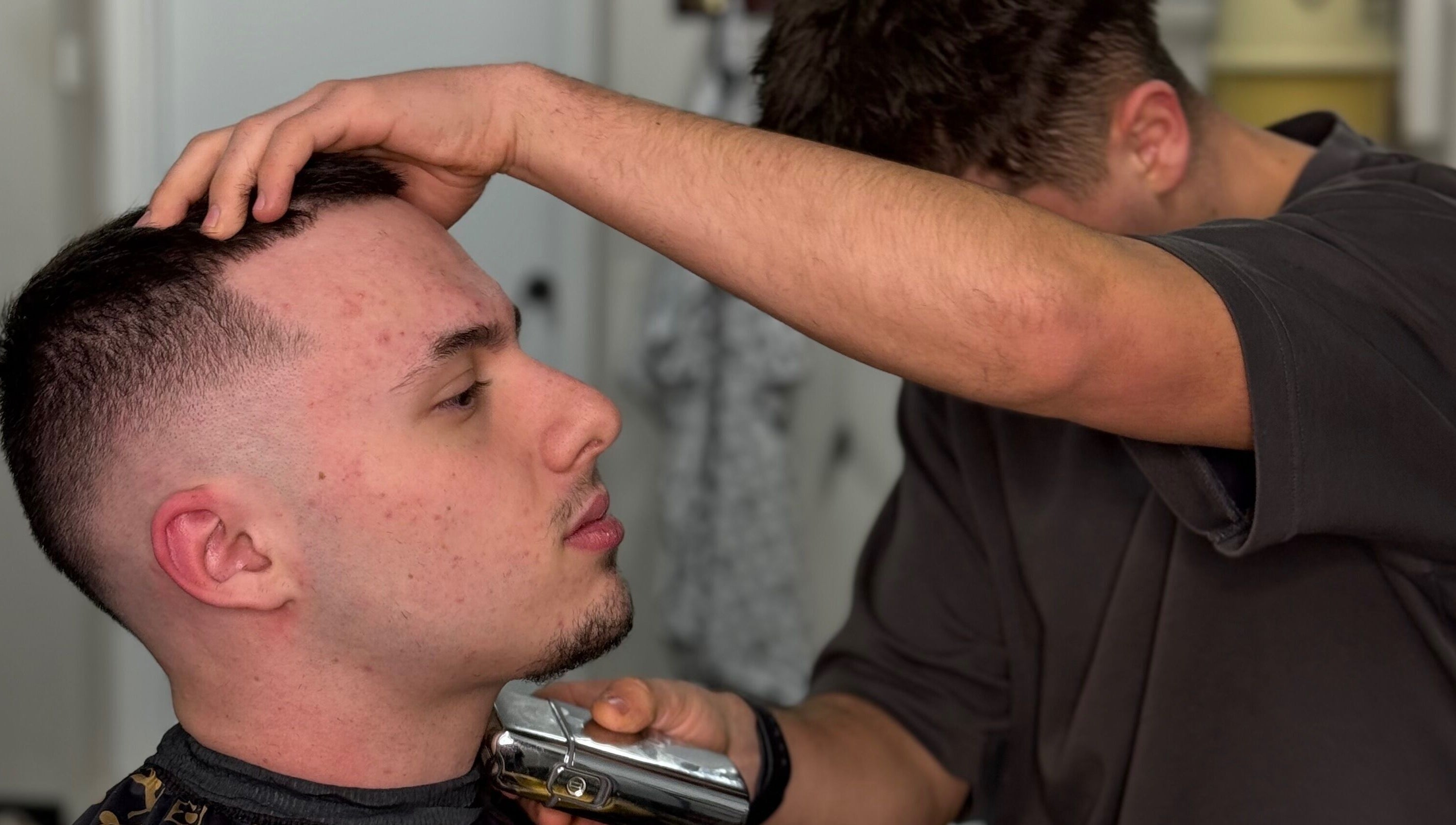 Barber giving a precise haircut at Chuckz Cutz, Melbourne, Victoria, AU. Close-up of expert styling.
