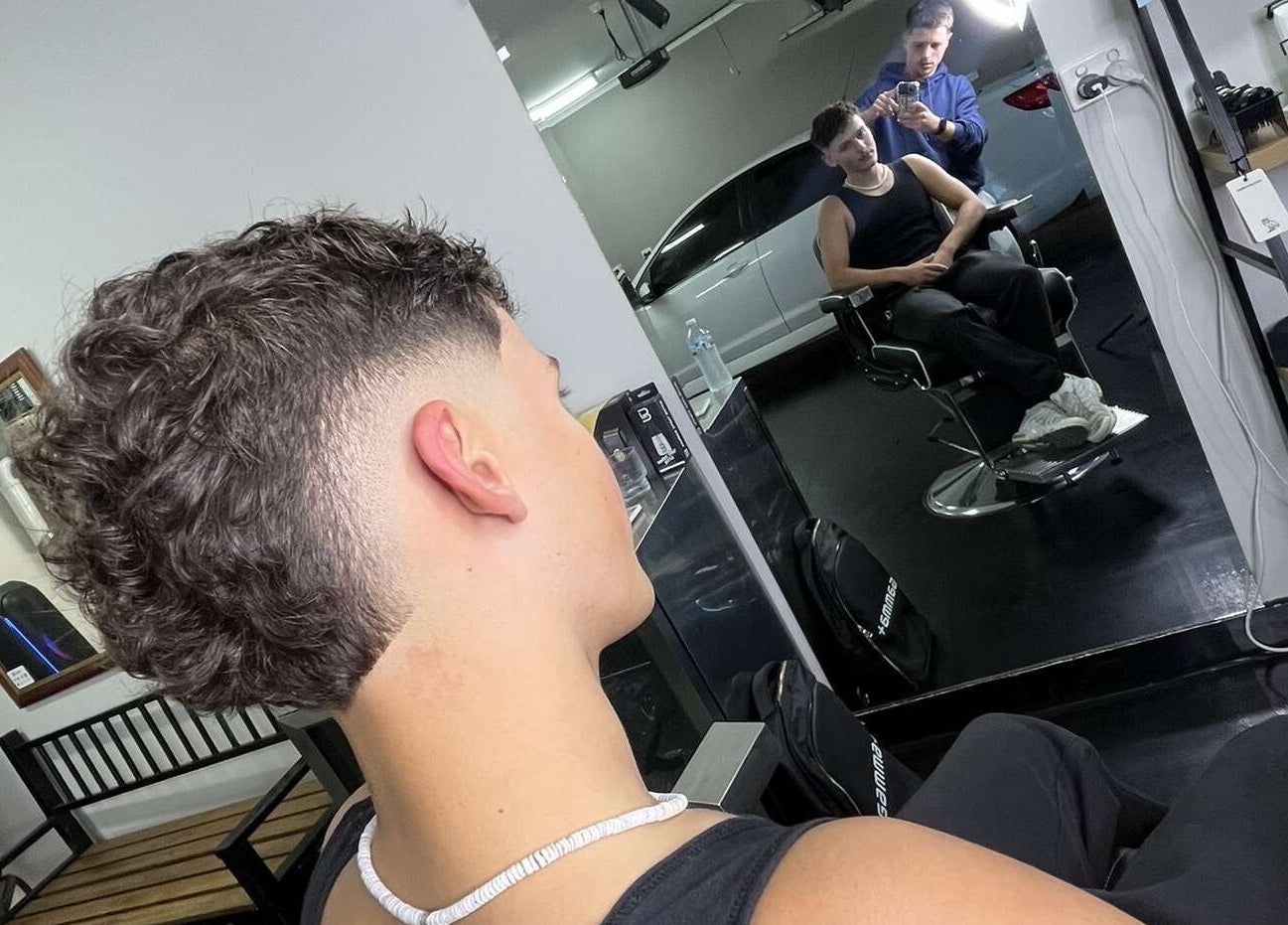 Modern haircut at Chuckz Cutz, Melbourne, Victoria, AU, showcasing a stylish fade in the mirror reflection.