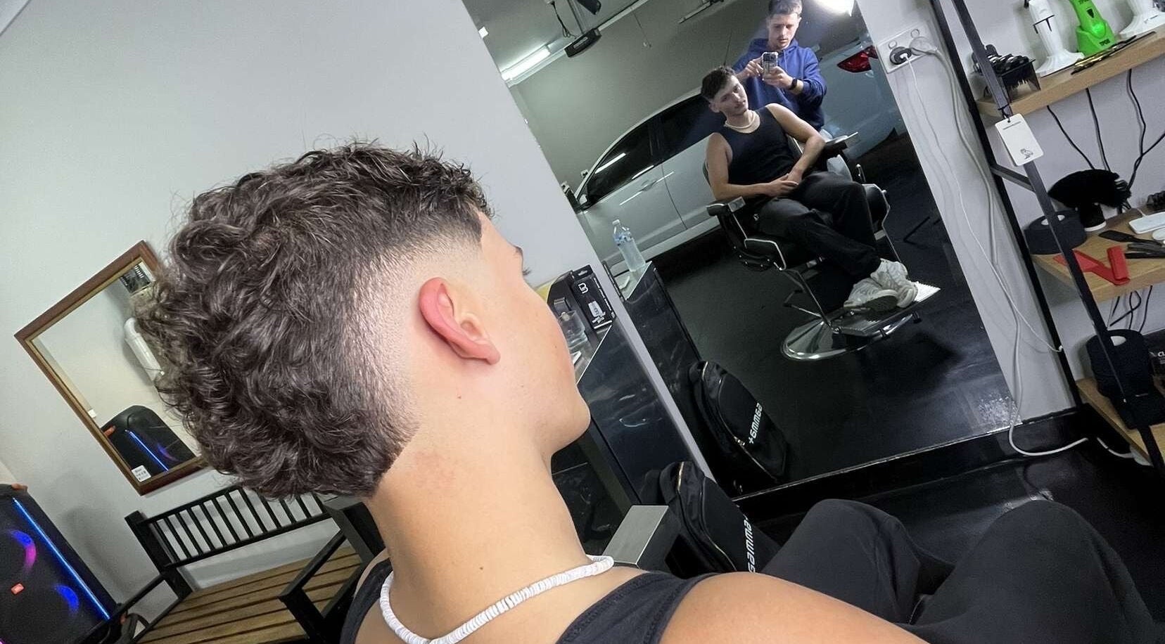 Modern haircut at Chuckz Cutz, Melbourne, Victoria, AU, showcasing a stylish fade in the mirror reflection.