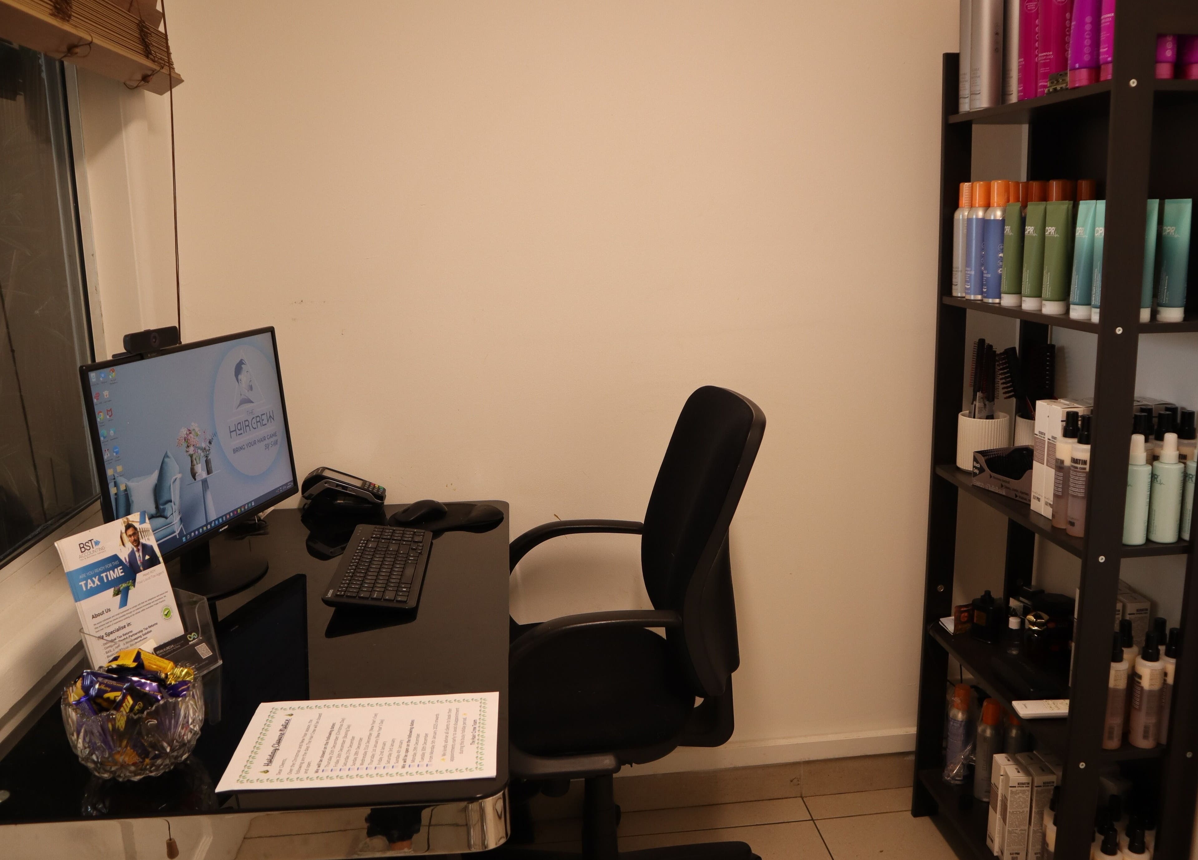 Modern workstation at The Hair Crew Sydney in Yagoona, New South Wales, AU, featuring beauty products on shelves.