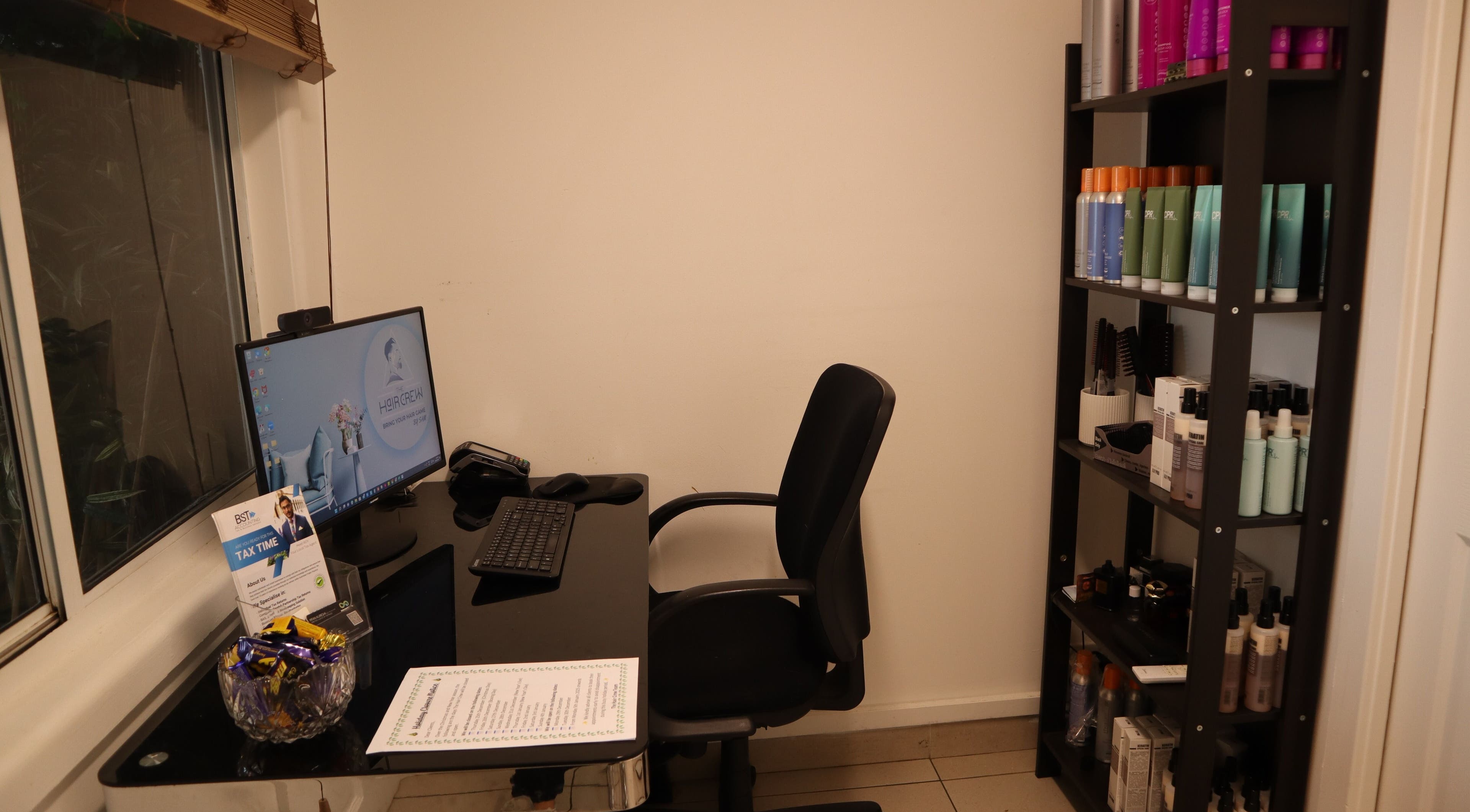 Modern workstation at The Hair Crew Sydney in Yagoona, New South Wales, AU, featuring beauty products on shelves.