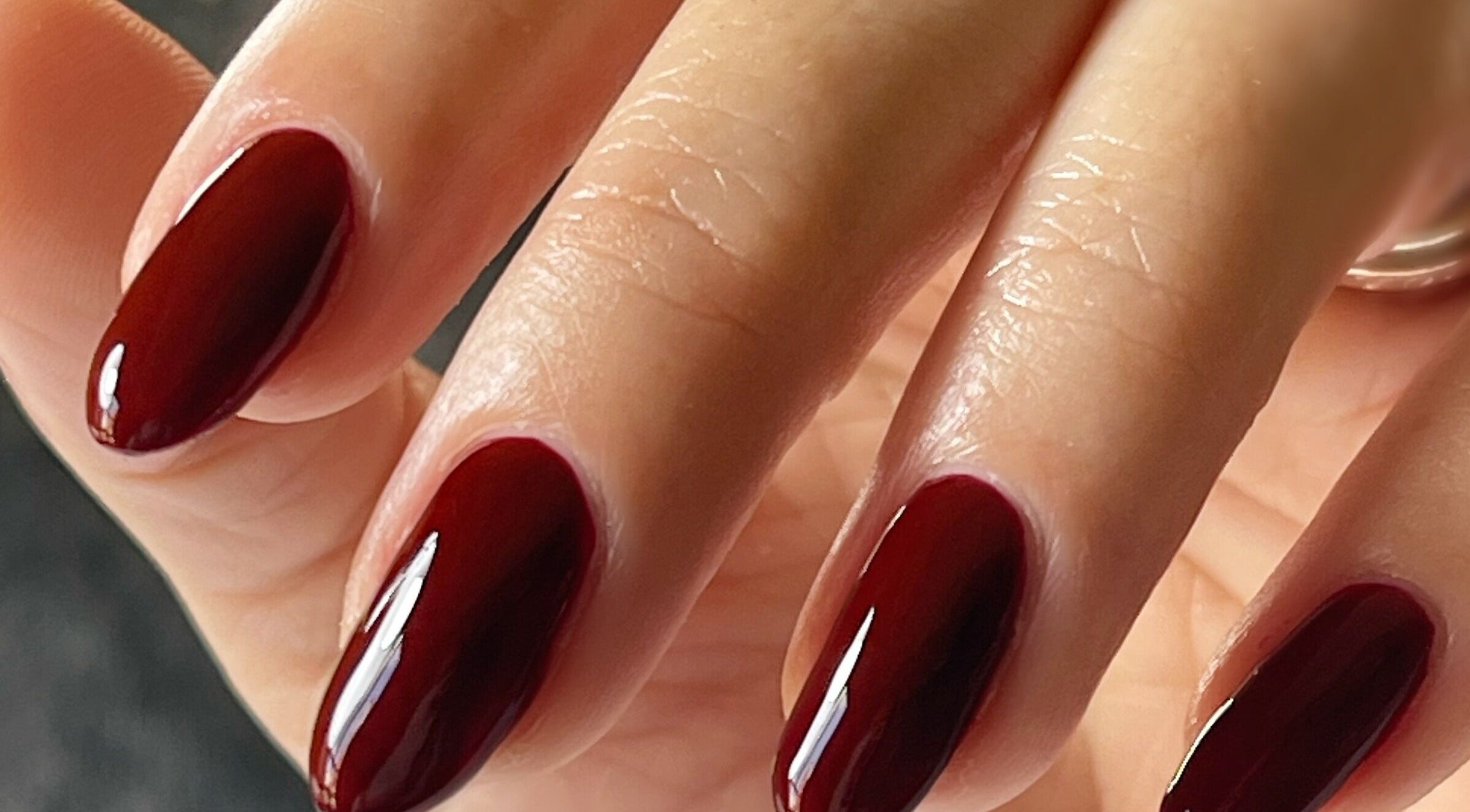 Close-up of manicured nails with deep red polish from Refresh Skin and Body, Salisbury, England, GB.
