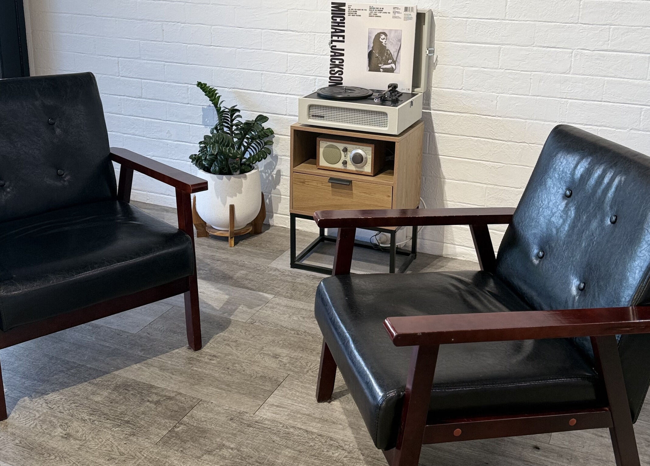 Cozy retro seating area at JK Barber Room in Kenmore, Queensland, AU with vintage decor and vinyl player.