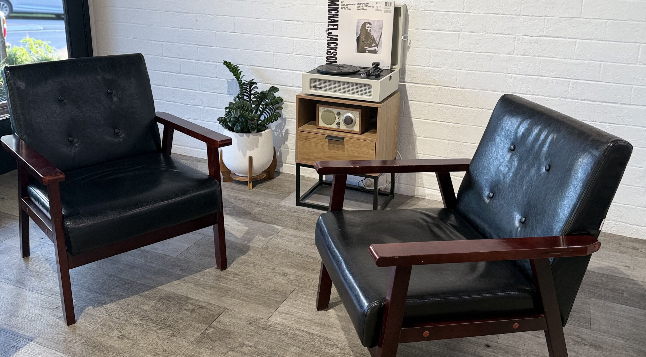 Cozy retro seating area at JK Barber Room in Kenmore, Queensland, AU with vintage decor and vinyl player.