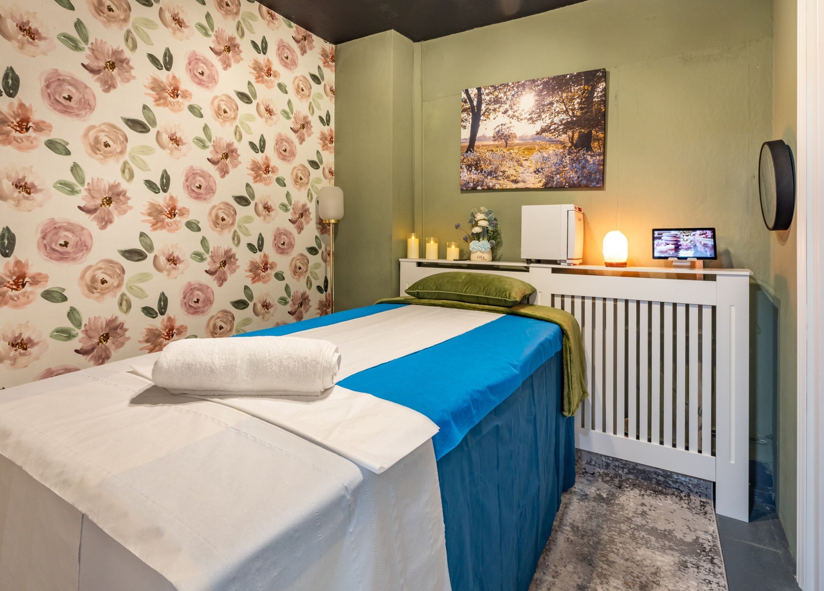 Relaxing treatment room at Fulham - Ambee Advanced Aesthetics & Wellness, London, England, GB, with floral decor.