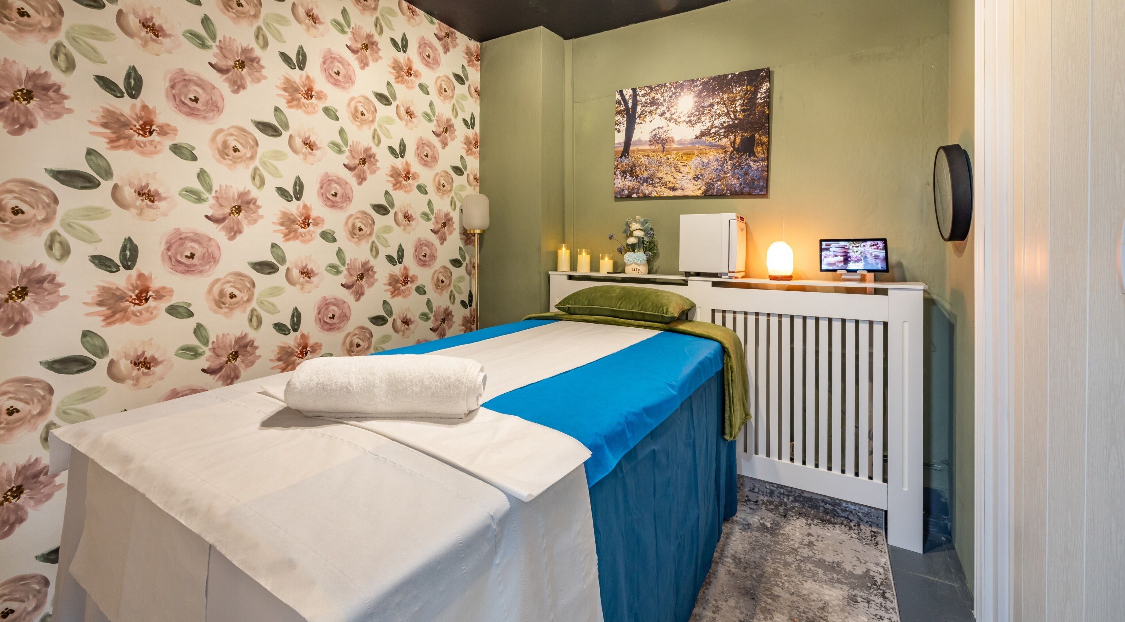 Relaxing treatment room at Fulham - Ambee Advanced Aesthetics & Wellness, London, England, GB, with floral decor.