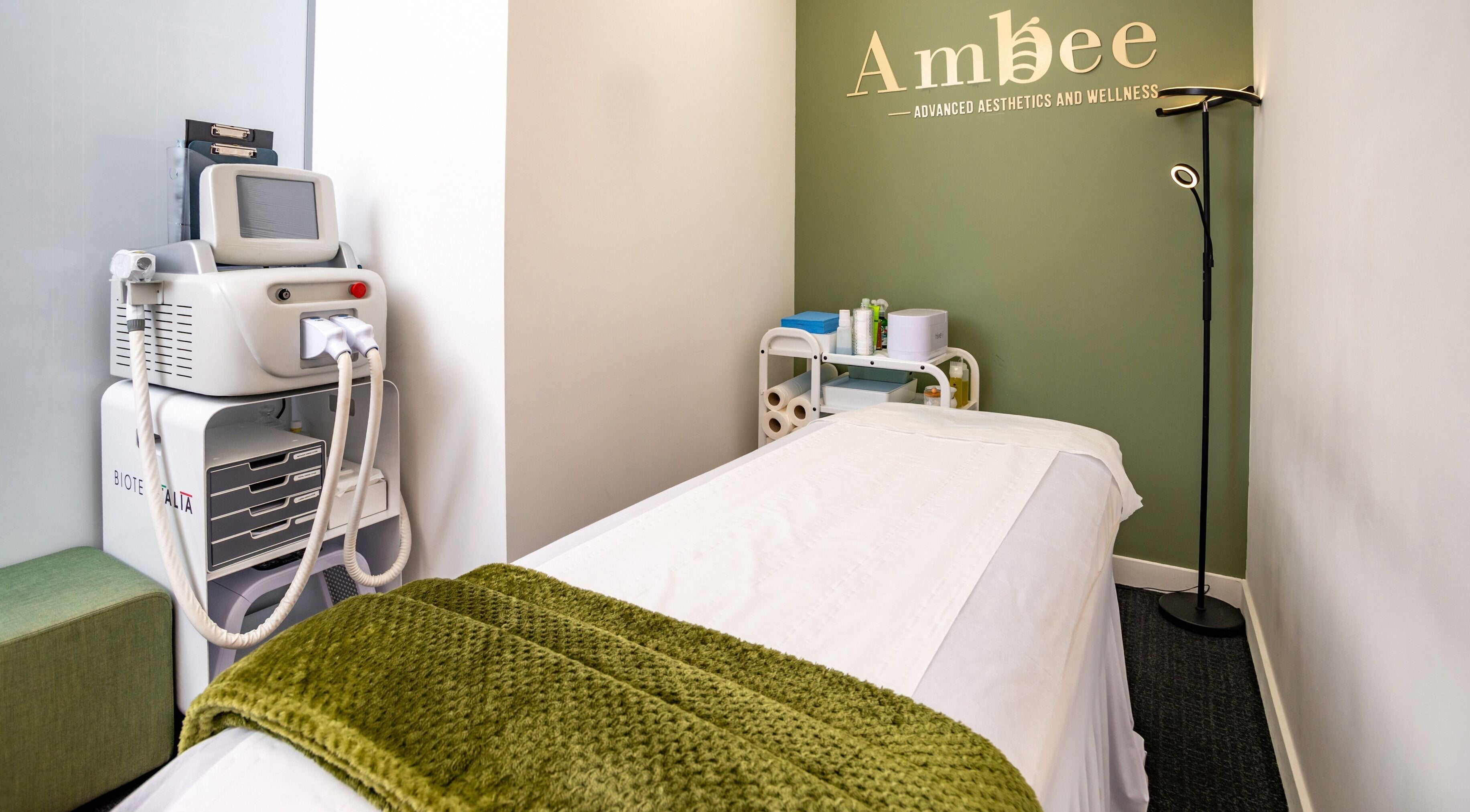 Treatment room at Canary Wharf-Ambee Beauty Clinic, London, England, GB with equipment and bed.